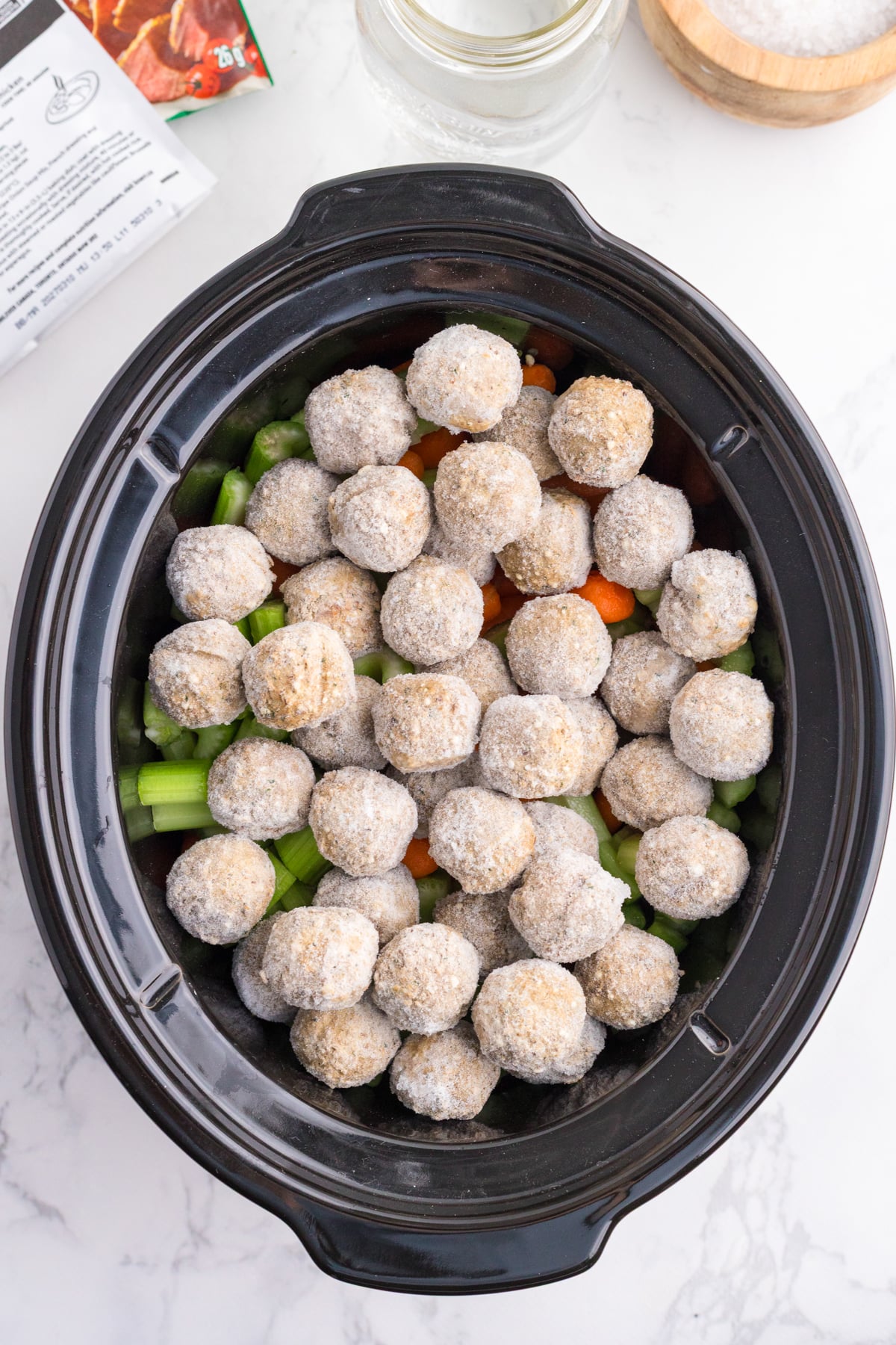Frozen meatballs and veggies in a slow cooker.