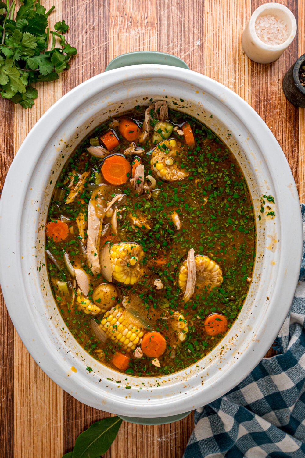 Caldo de pollo in a slow cooker after cilantro is stirred in.