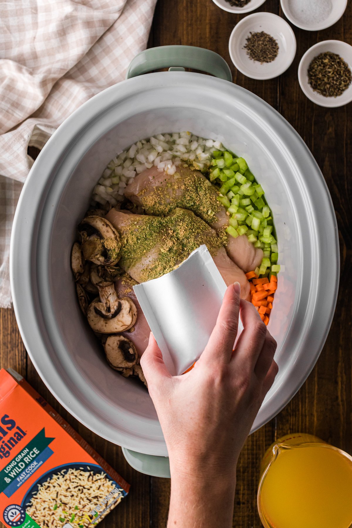Pouring seasoning packet into a slow cooker.