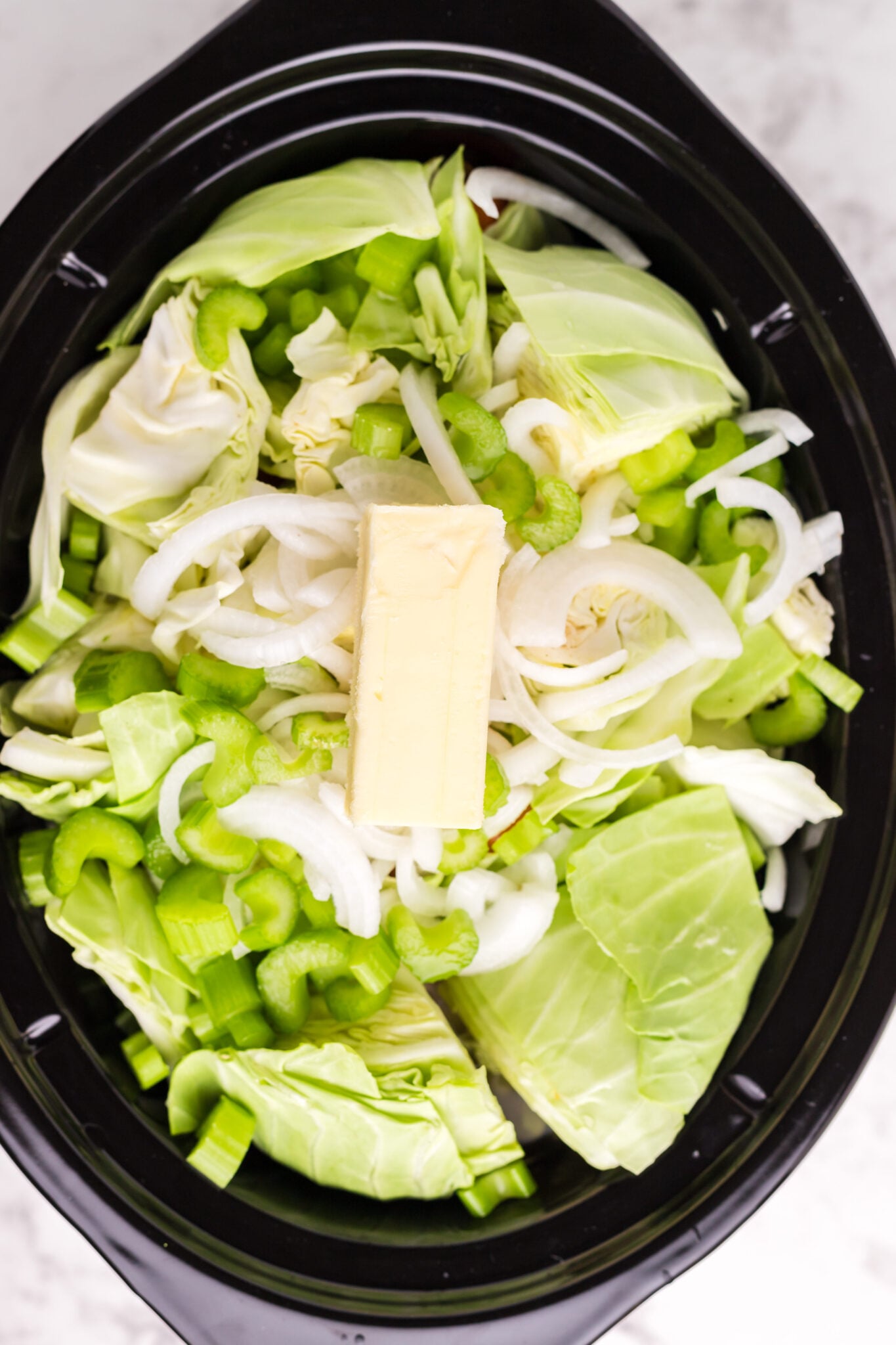 cabbage, onion and butter on top of the carrots, potatoes and corned beef.