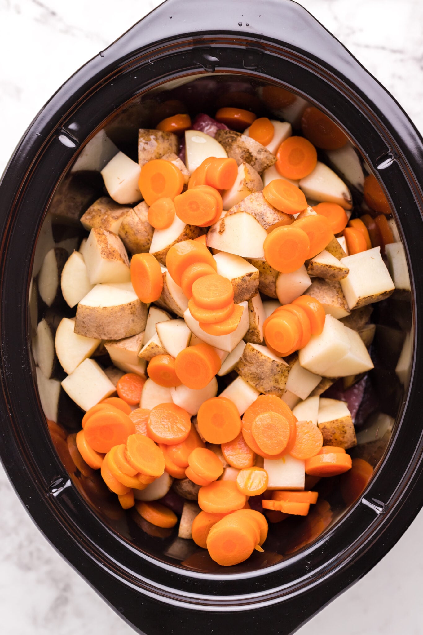 carrots, potatoes and corned beef in a slow cooker.
