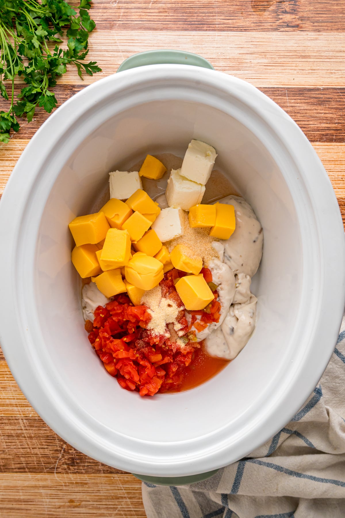 Mushroom soup, rotel, cream cheese, velveeta, and seasonings in a crockpot.