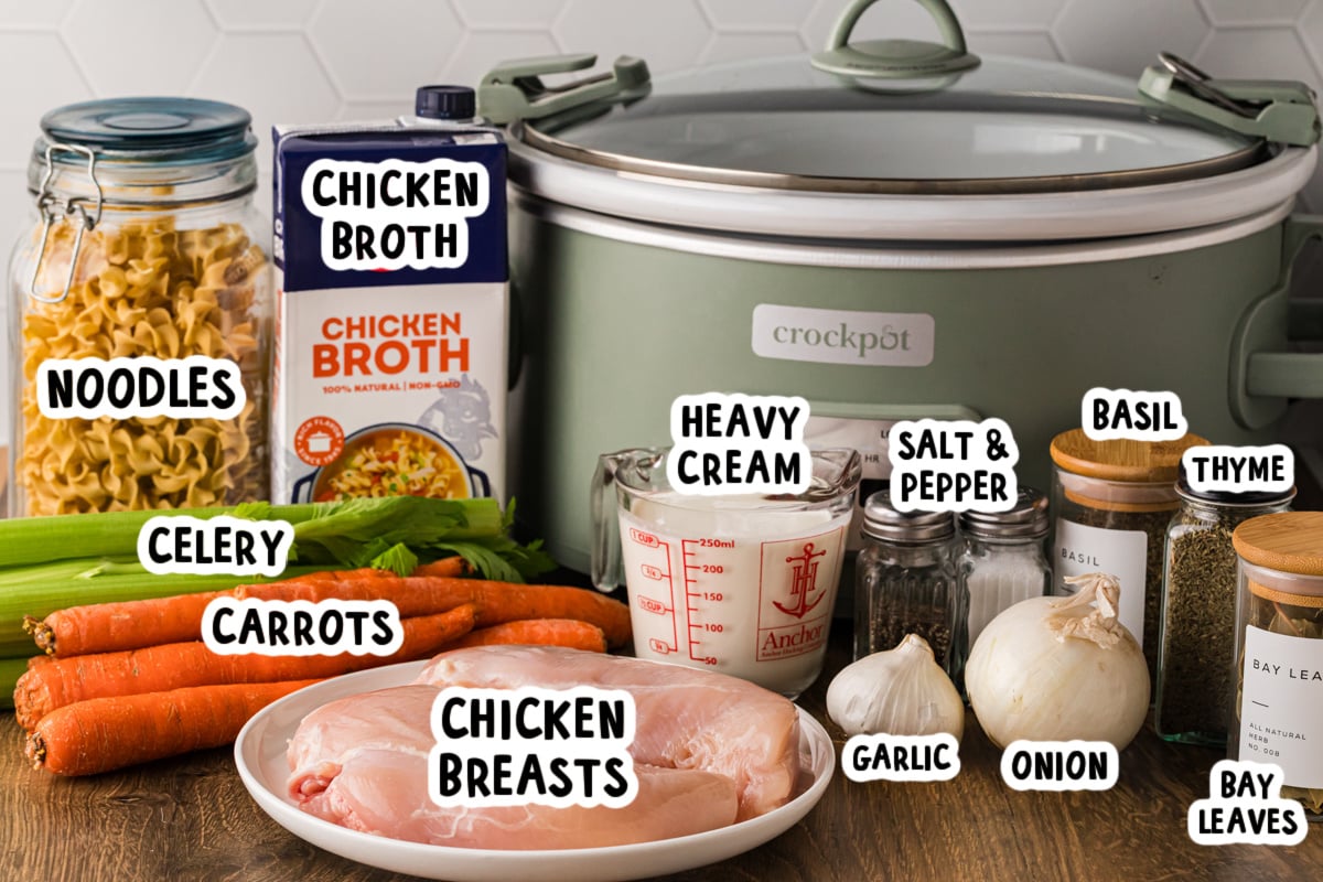 Ingredients for creamy chicken noodle soup on a table.