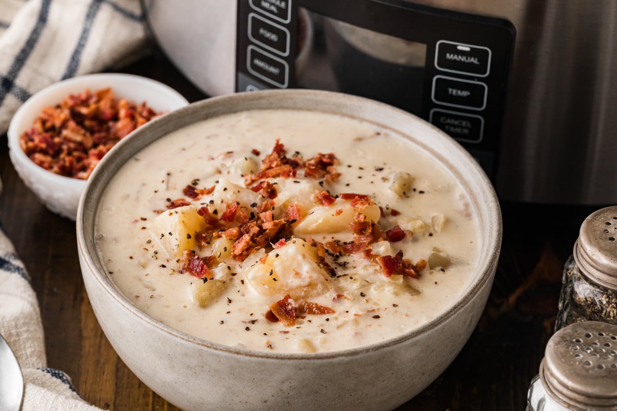 A serving of potato bacon soup in a white bowl.