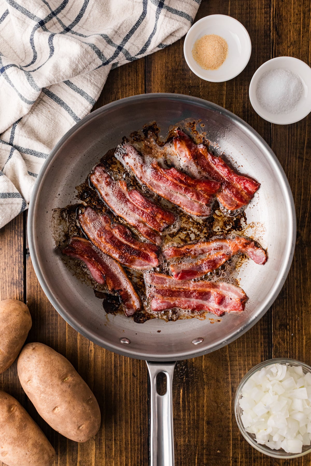 Cooked bacon strips in a skillet.
