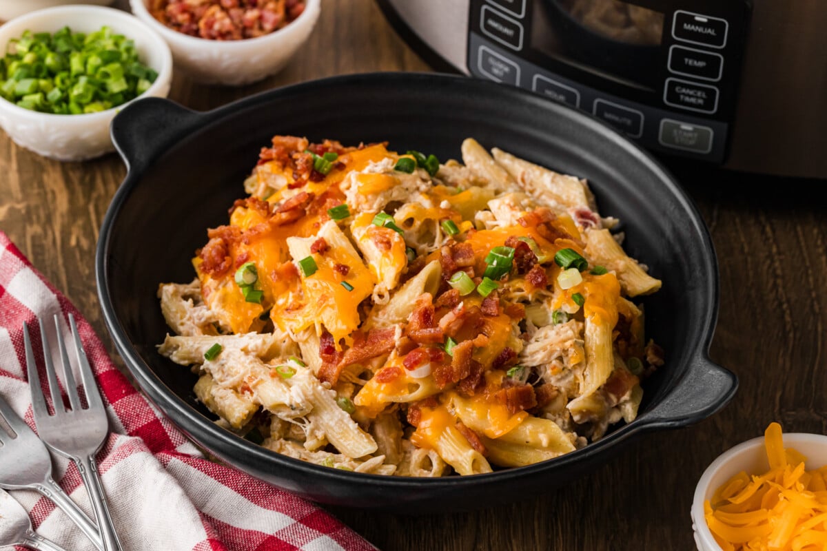A black bowl filled with crack chicken pasta.