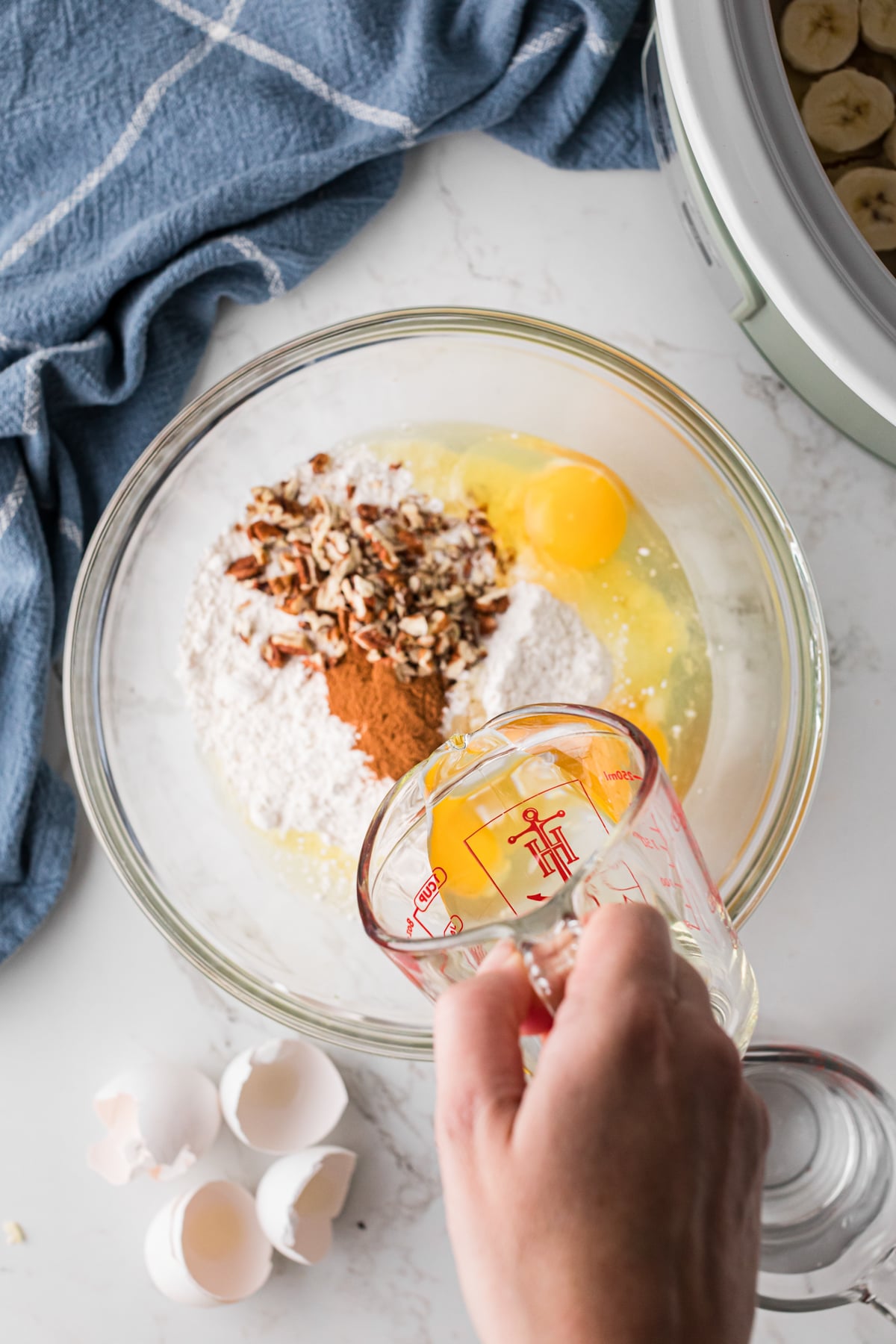 Pouring vegetable oil into a bowl of cake ingredients.