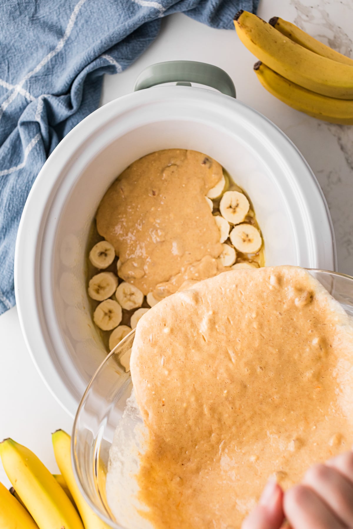 Pouring prepared cake mix into a crockpot.