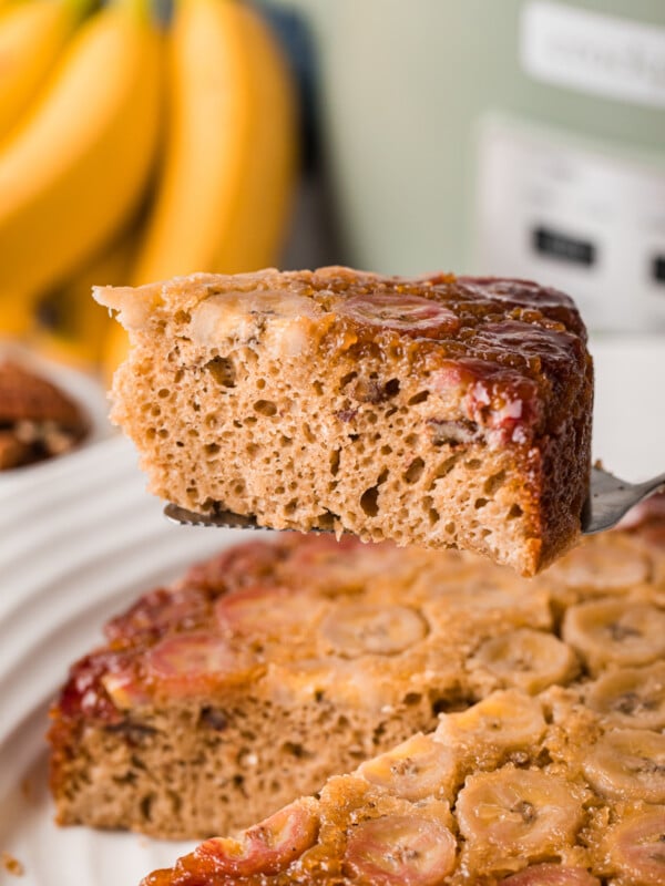 Holding a slice of banana upside down cake over a crockpot.