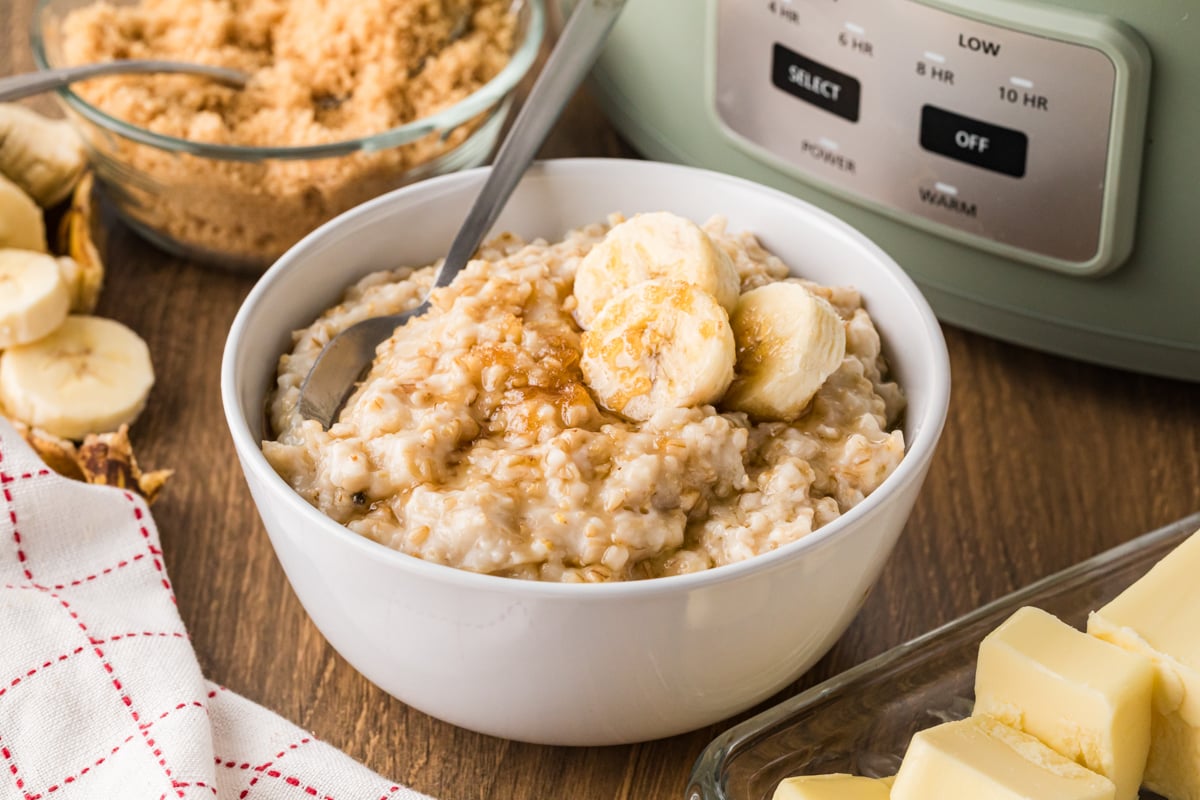 A serving of oatmeal with bananas on it in a white bowl.