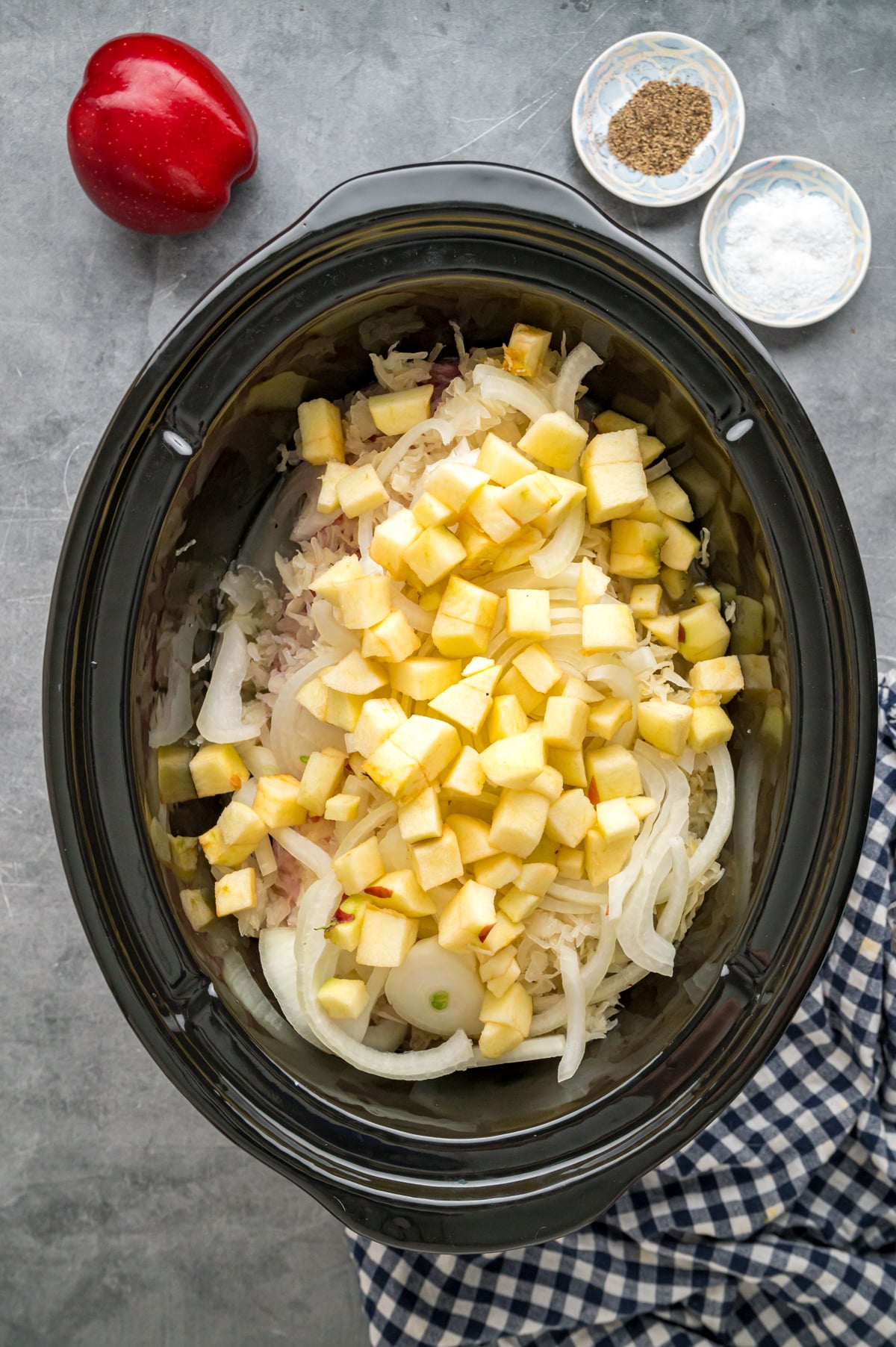 Ingredients for pork and sauerkraut in a crockpot before cooking.