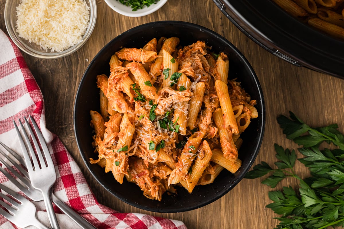 A serving of chicken pasta rosa in a black bowl.