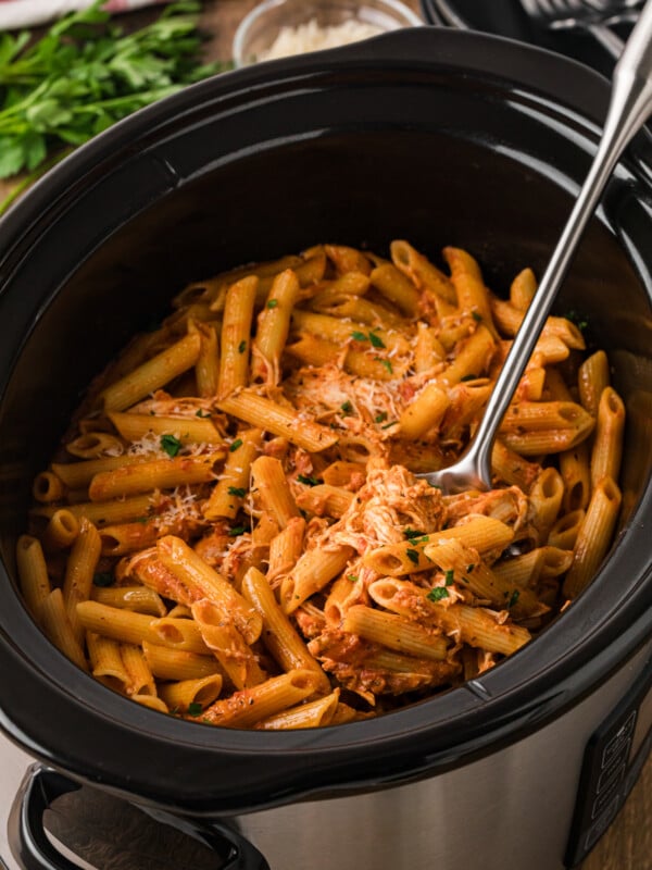 Chicken pasta rosa in a crockpot with a large metal spoon.