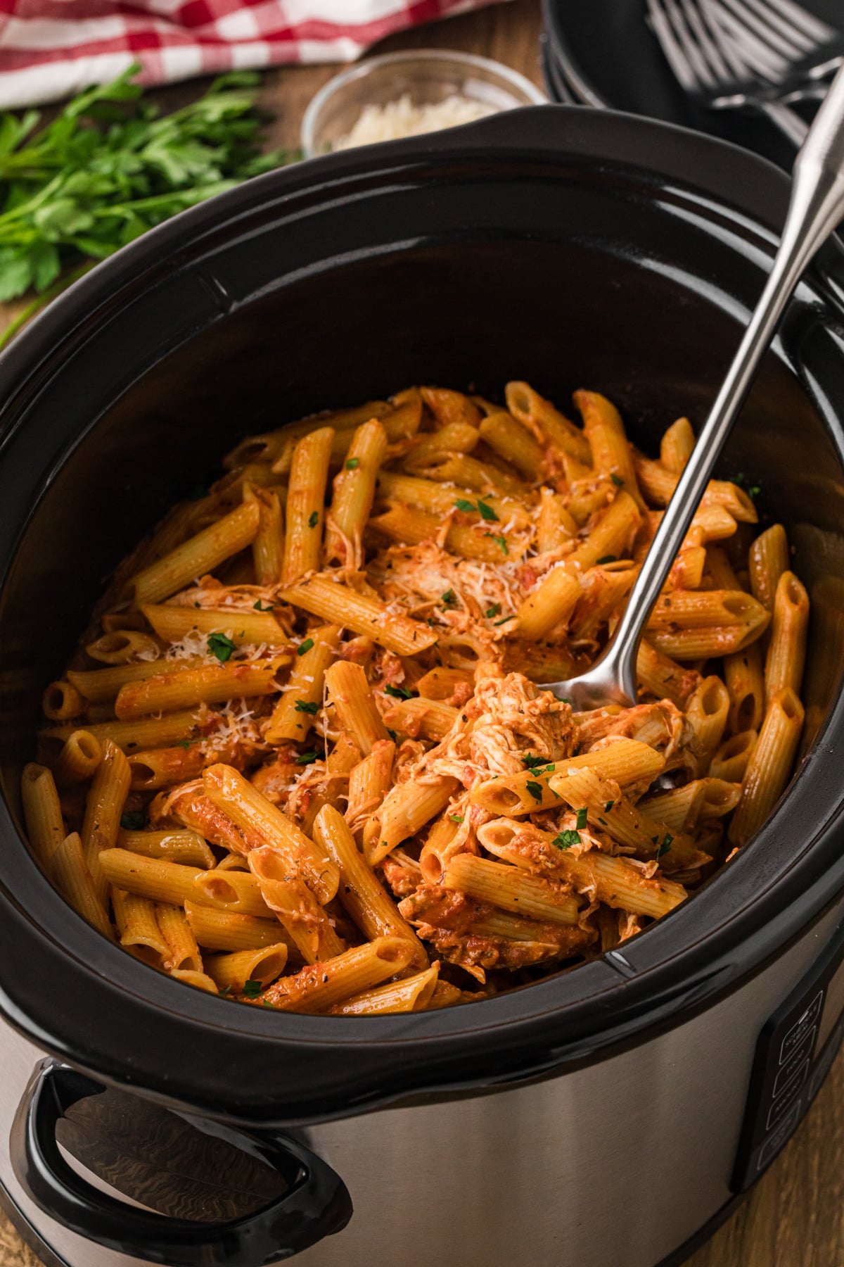 Chicken pasta rosa in a crockpot with a large metal spoon.