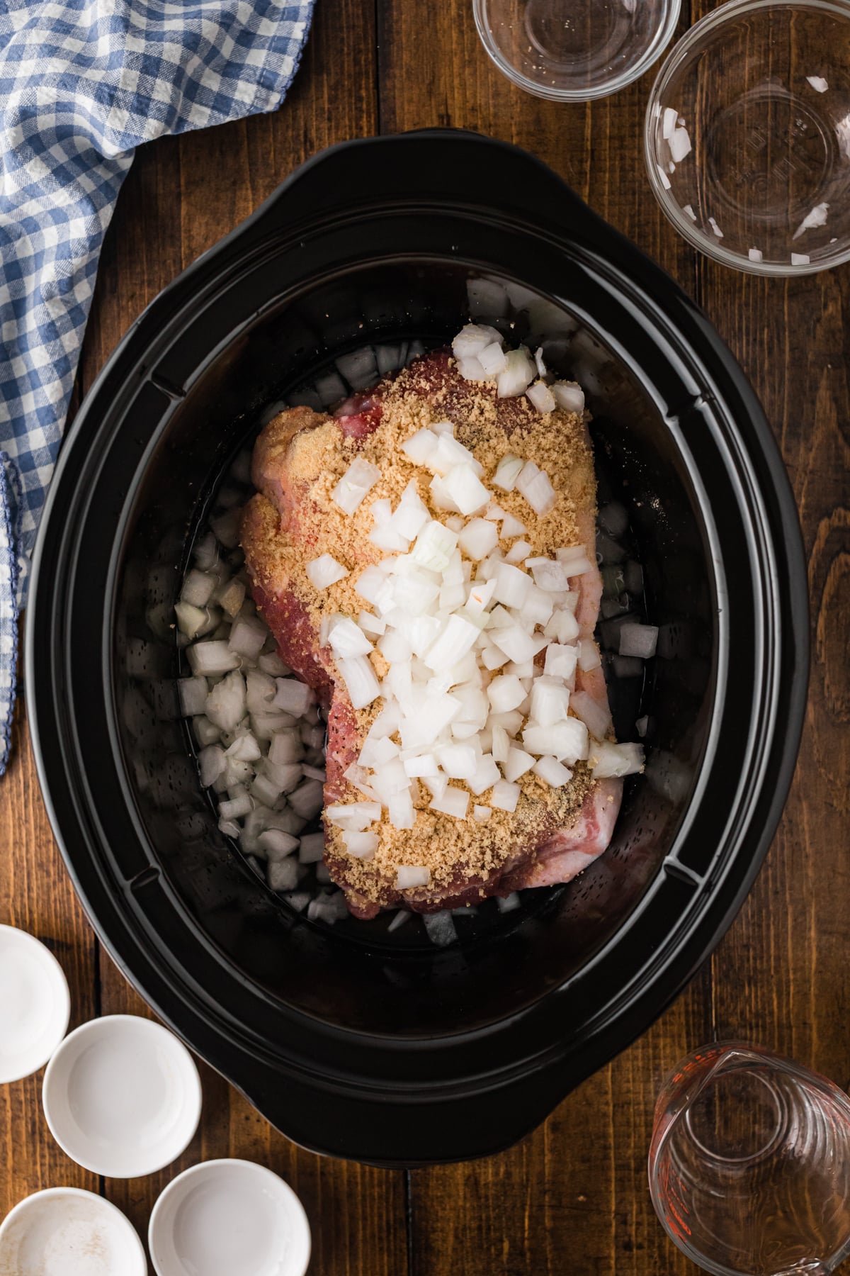 Pork, brown sugar, onion, seasonings, and water in a crockpot.