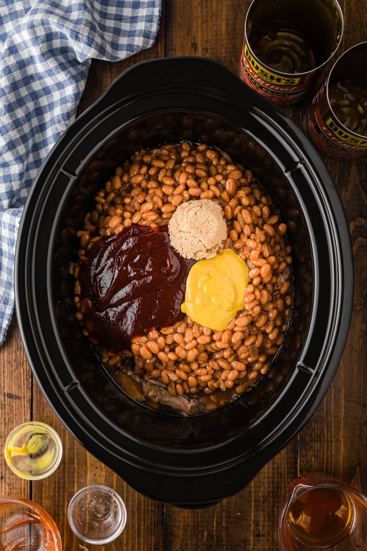 Beans, mustard, bbq sauce, and brown sugar added to pork in a crockpot.