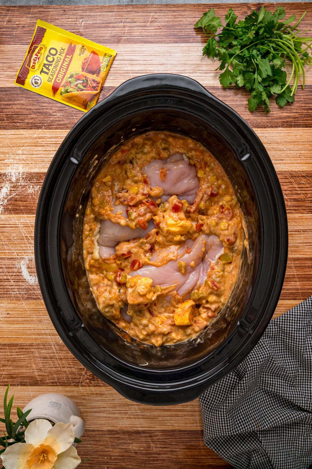 Chicken breasts submerged in a creamy mixture in a crockpot.