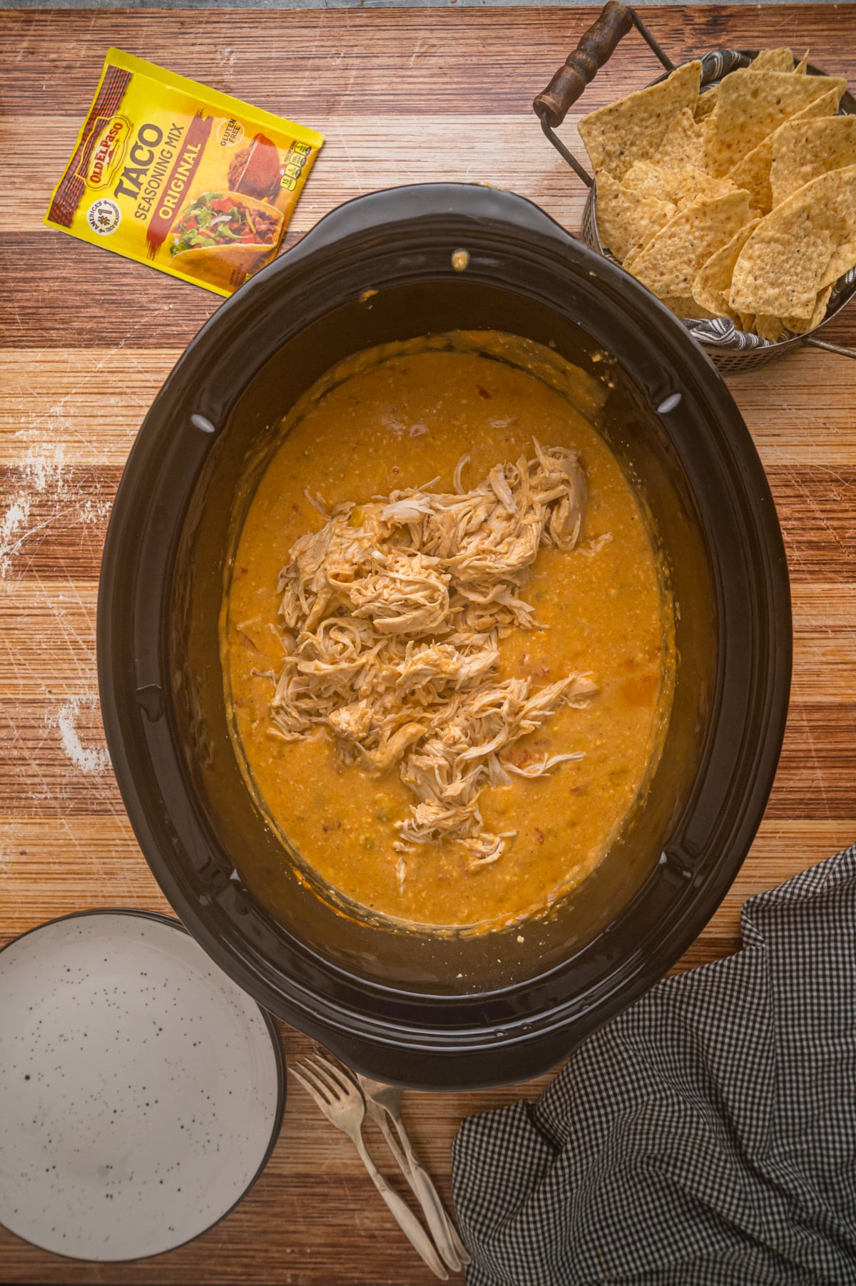 Shredded chicken in liquid in a crockpot.