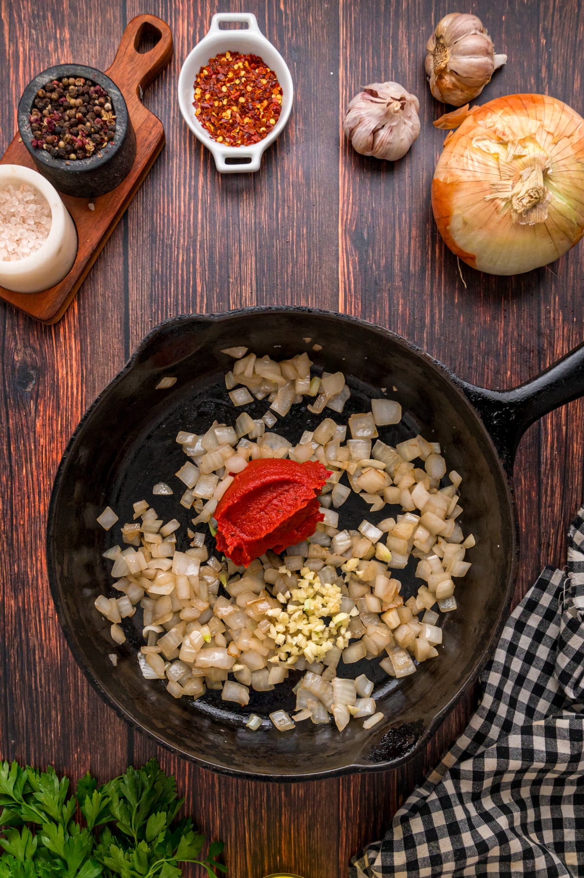 Onion, garlic, and tomato paste cooking in a skillet.