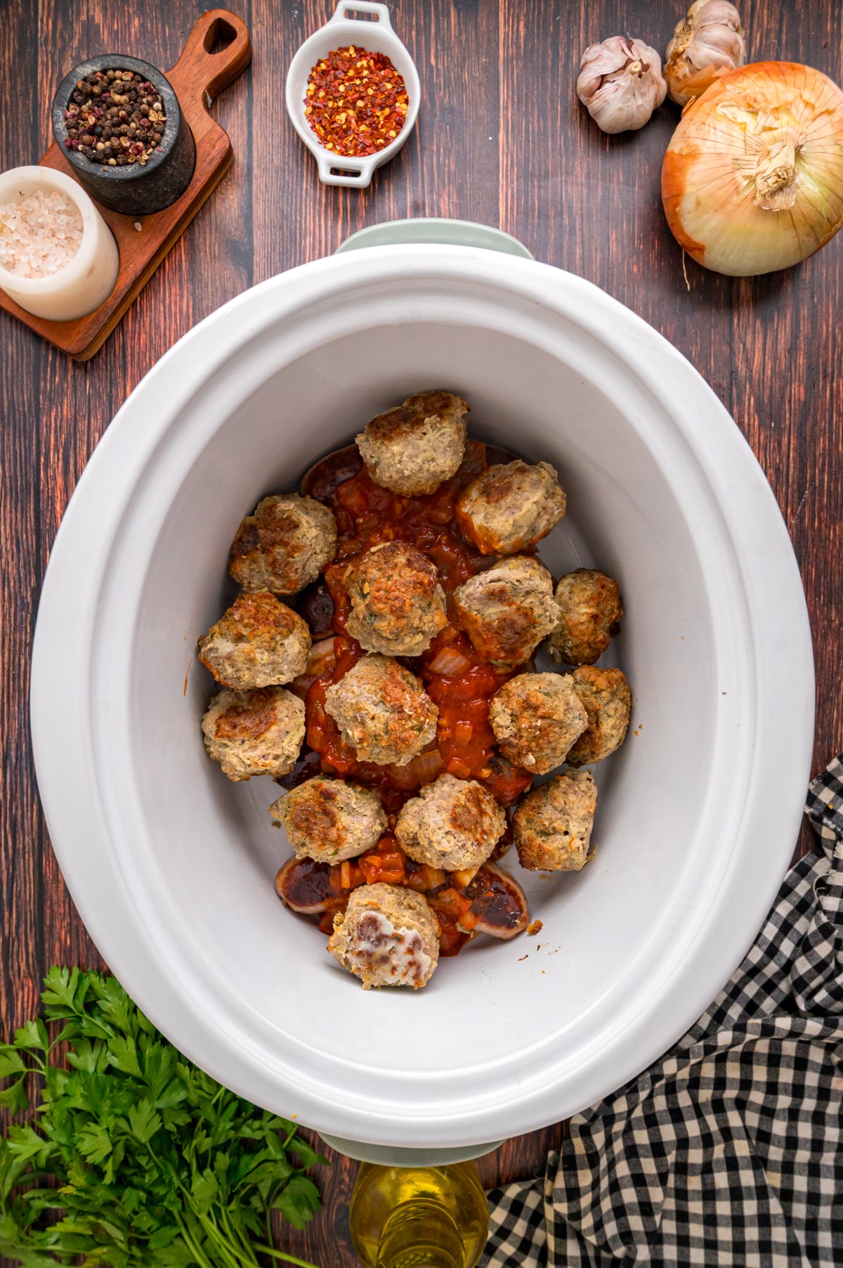 Browned sausage, onion mixture, and meatballs in a slow cooker.
