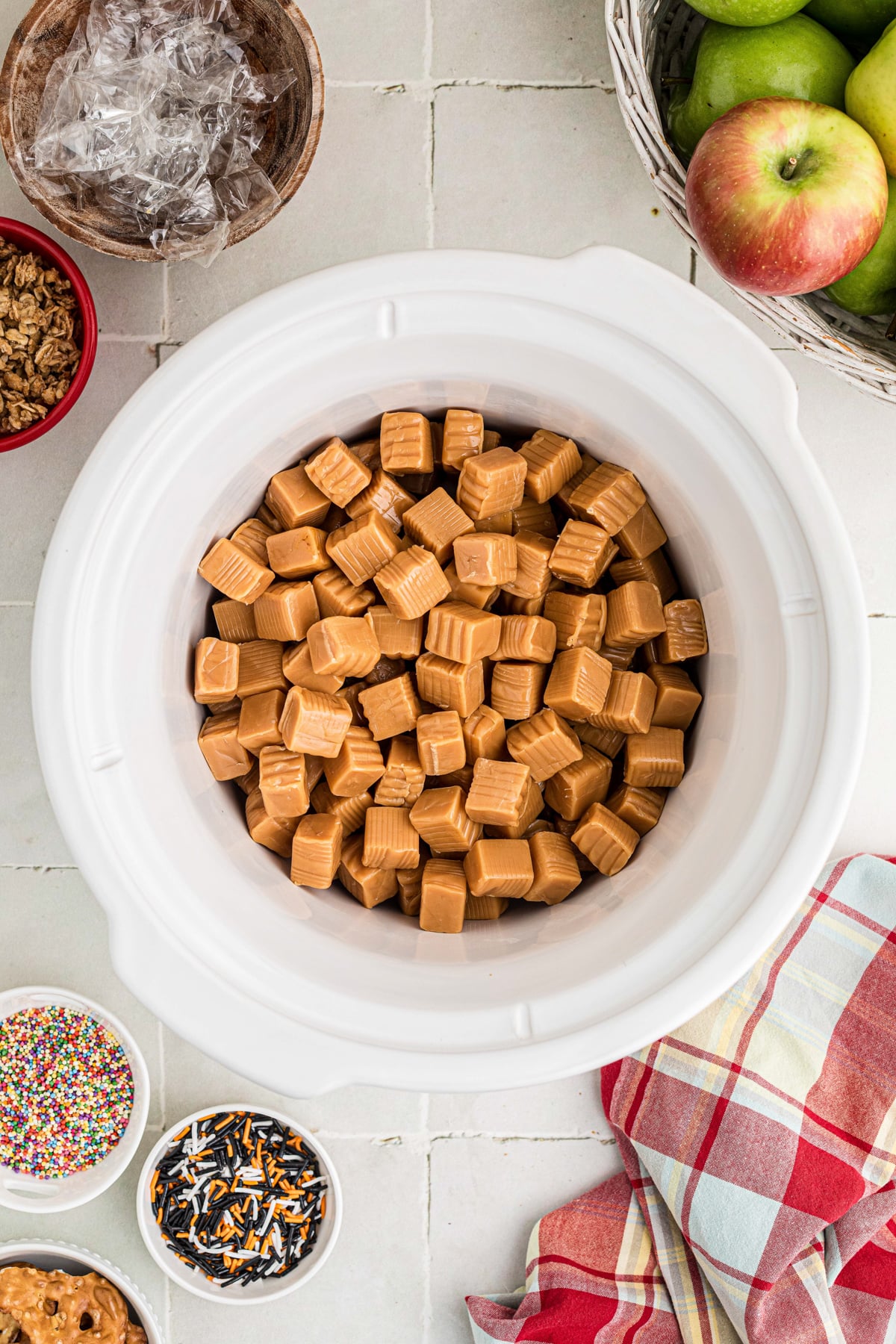Unwrapped caramel candies in a crockpot.